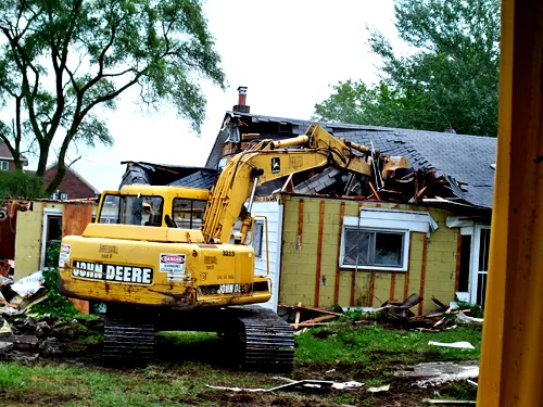 Excavator taking down a house