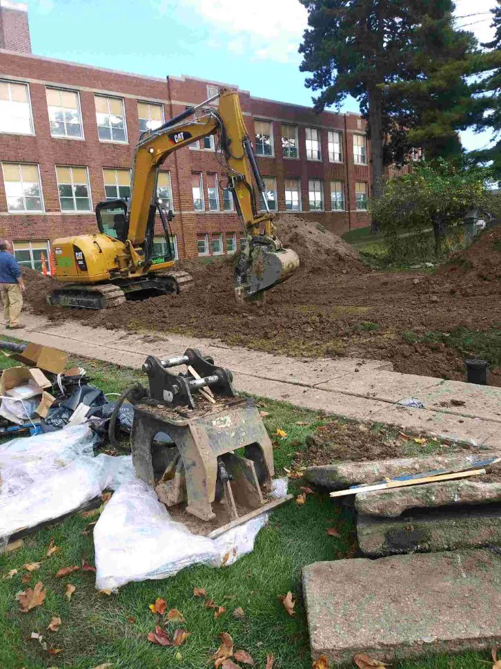 Excavator working alongside a commercial building