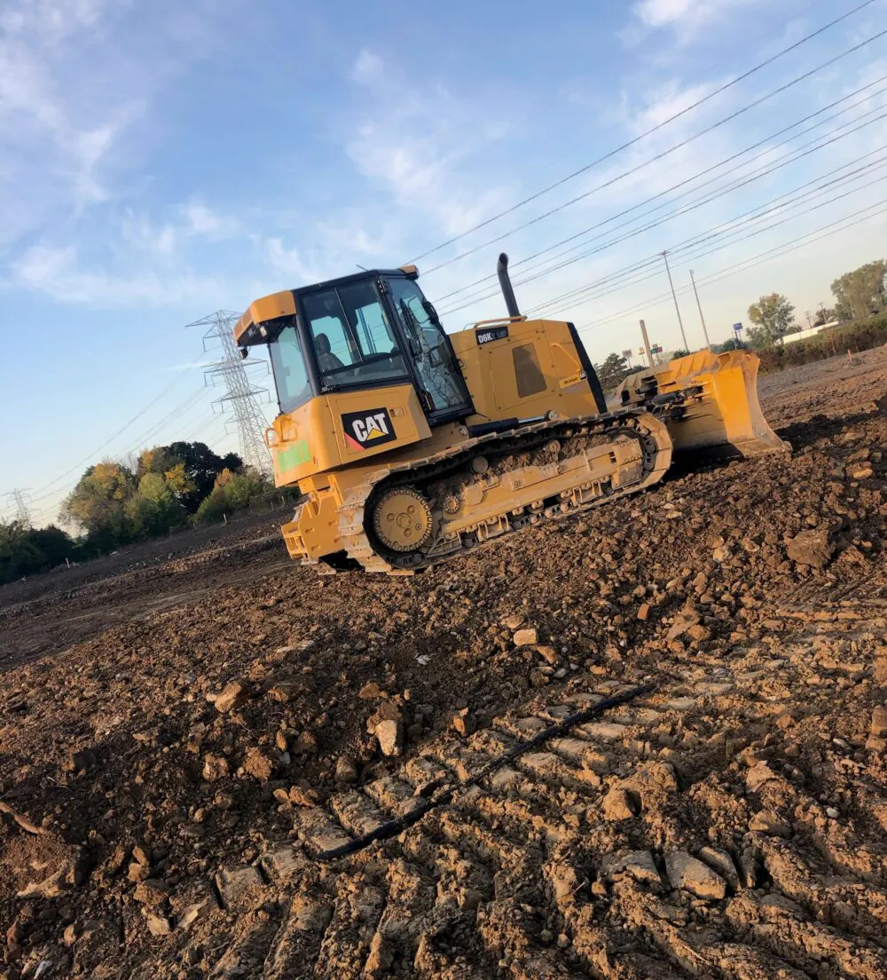 Dozer moving material across a large site