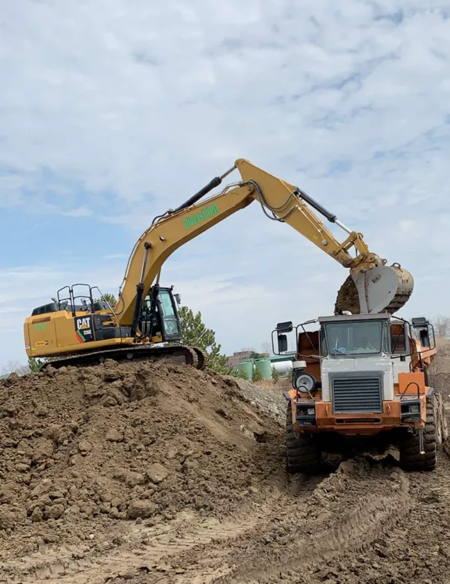 Excavator loading a haul truck on a dirt site